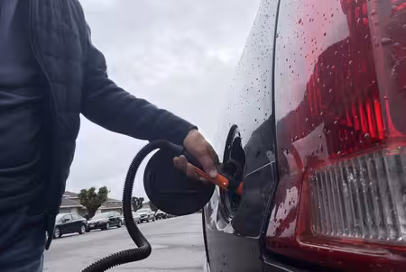 Red fuel can on a highway shoulder next to a car