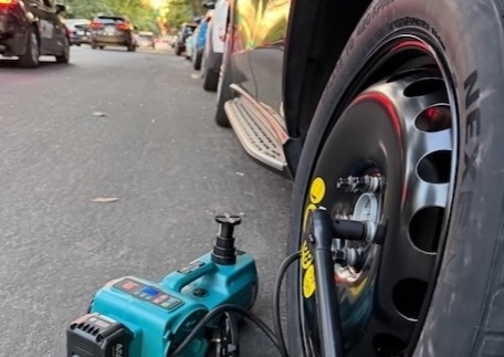 Technician changing a passenger-car tire with an impact wrench